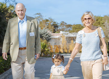 Photo of an older man and woman holding a child's hands. Link to Life Stage Gift Planner Over Age 65 Situations.