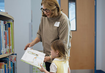 Photo of a woman reading a book to a child. Links to Tangible Personal Property page.